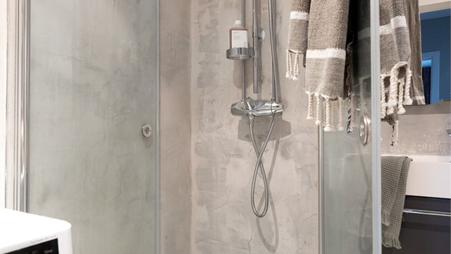 Dusjhjørnet har praktiske, innfellbare glassvegger. Det er også opplegg for vaskemaskin.