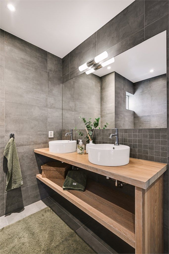 Innredningen har doble, toppmonterte servanter og et stort speil.