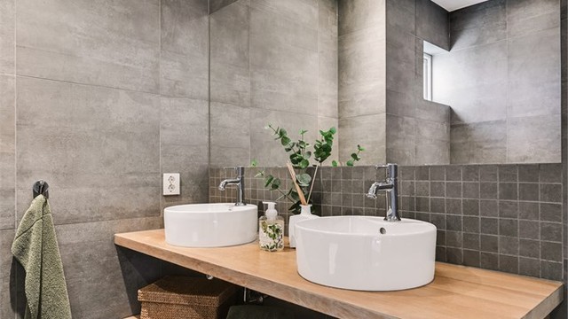 Innredningen har doble, toppmonterte servanter og et stort speil.