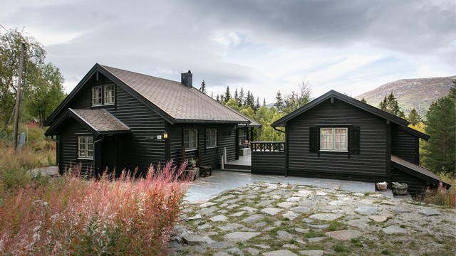 Hovedhytte og anneks danner et helhetlig hyttetun med mørkbeiset kledning.