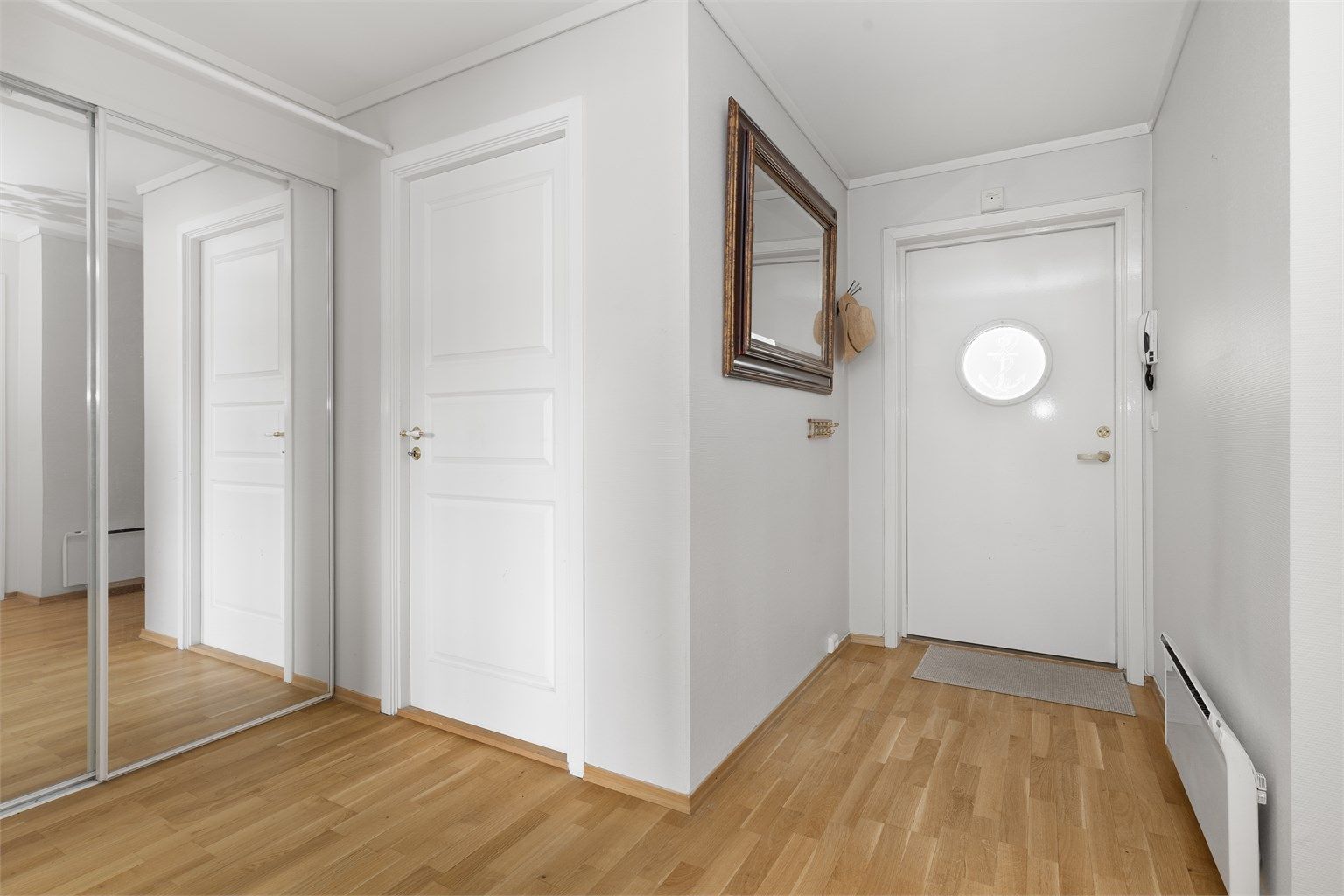 Gangen har parkett på gulv og god plass til oppbevaring i skyvedørsgarderobe. Bygget har heis og porttelefon.