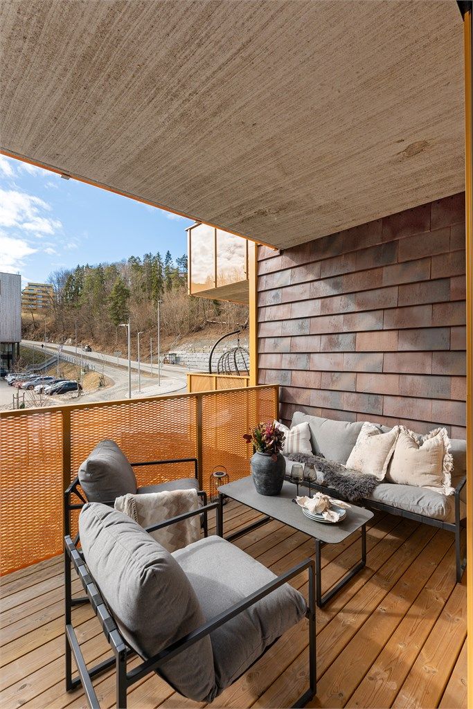 Gulvet er belagt med terrassebord, og rekkverket i metall gir et åpent uttrykk.