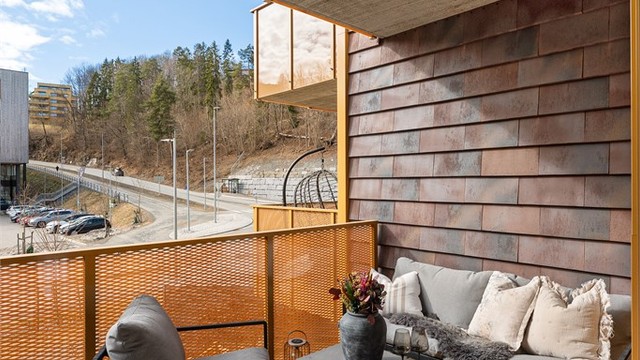 Gulvet er belagt med terrassebord, og rekkverket i metall gir et åpent uttrykk.