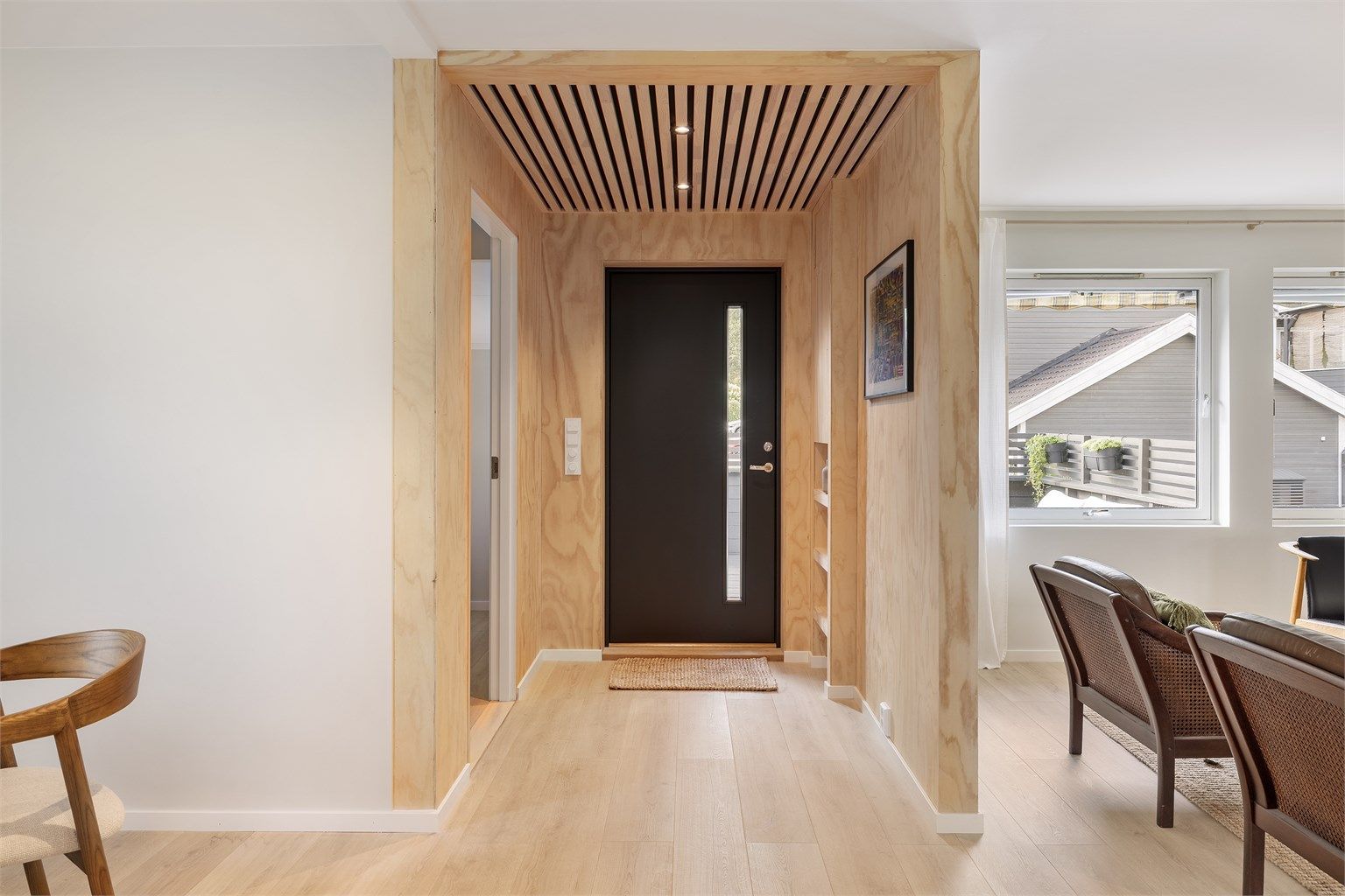 Velkommen inn! Entré med vegger i finér og spilehimling med downlights.