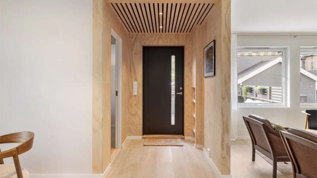 Velkommen inn! Entré med vegger i finér og spilehimling med downlights.
