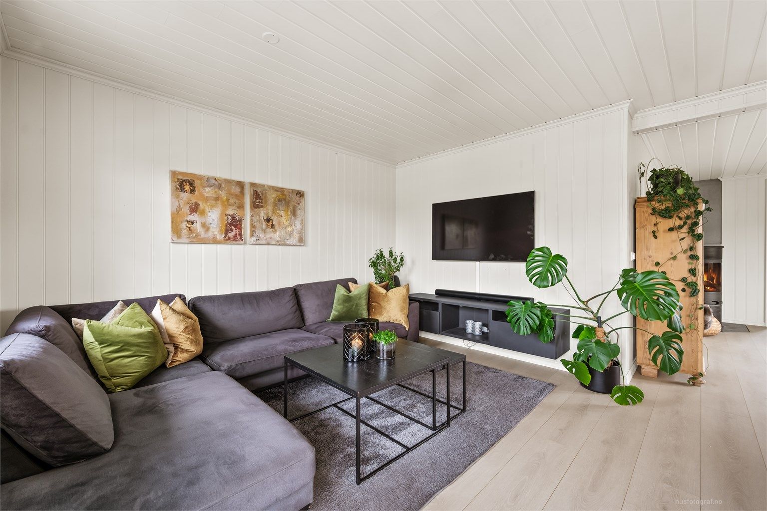 Gjennomgående materialvalg med malte panelplater på veggene og panelbord i himlingen.