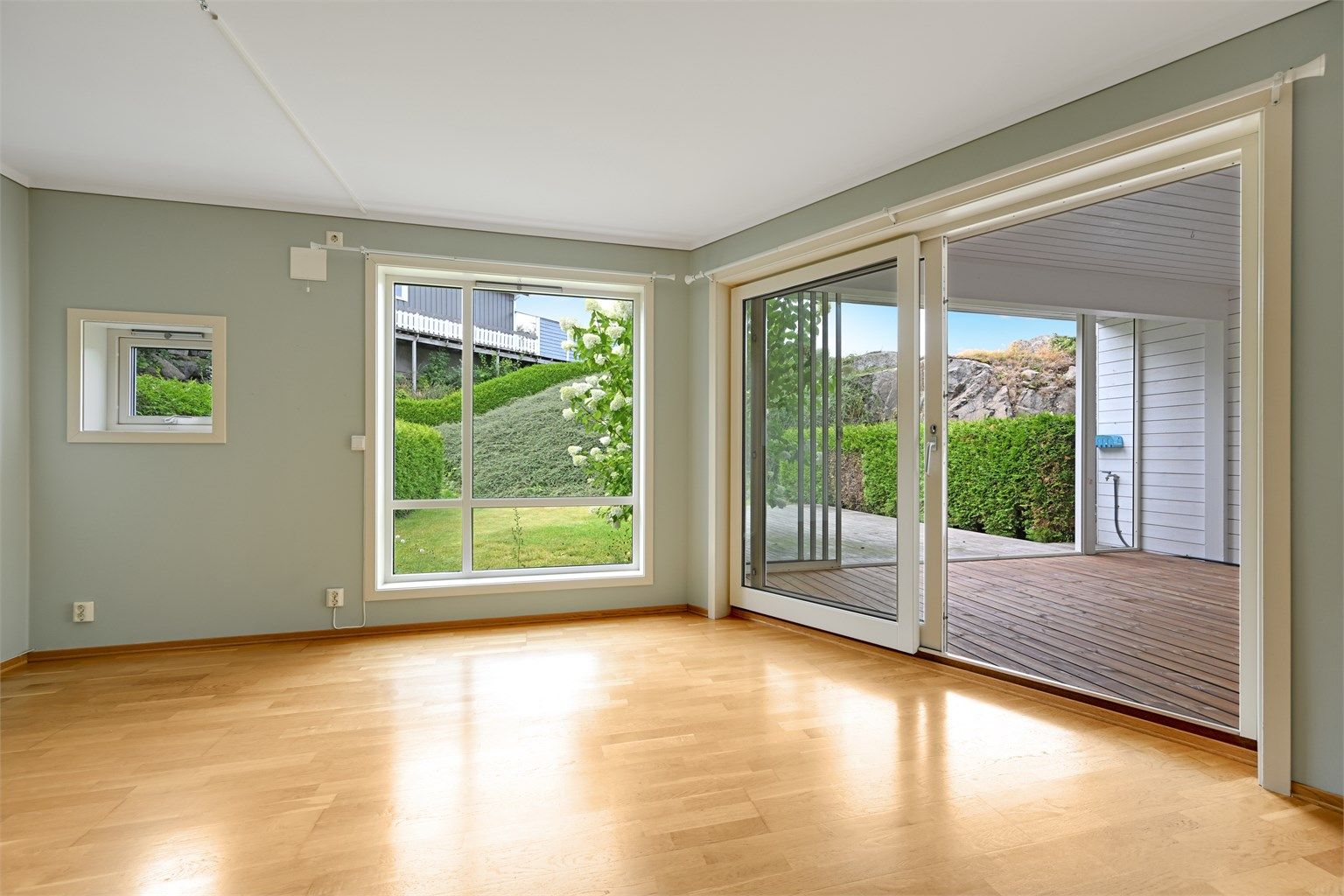 Fra stuen er det direkte utgang til den innglassede terrassen og markterrassen.