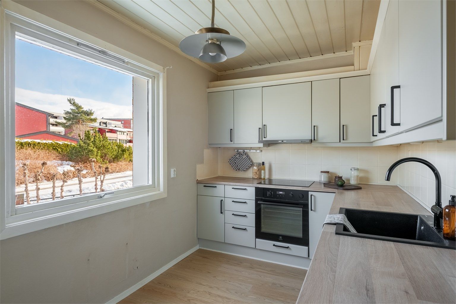 Kjøkkenet har godt med arbeidslys fra vinduet over en benkeplate med laminert overflate.