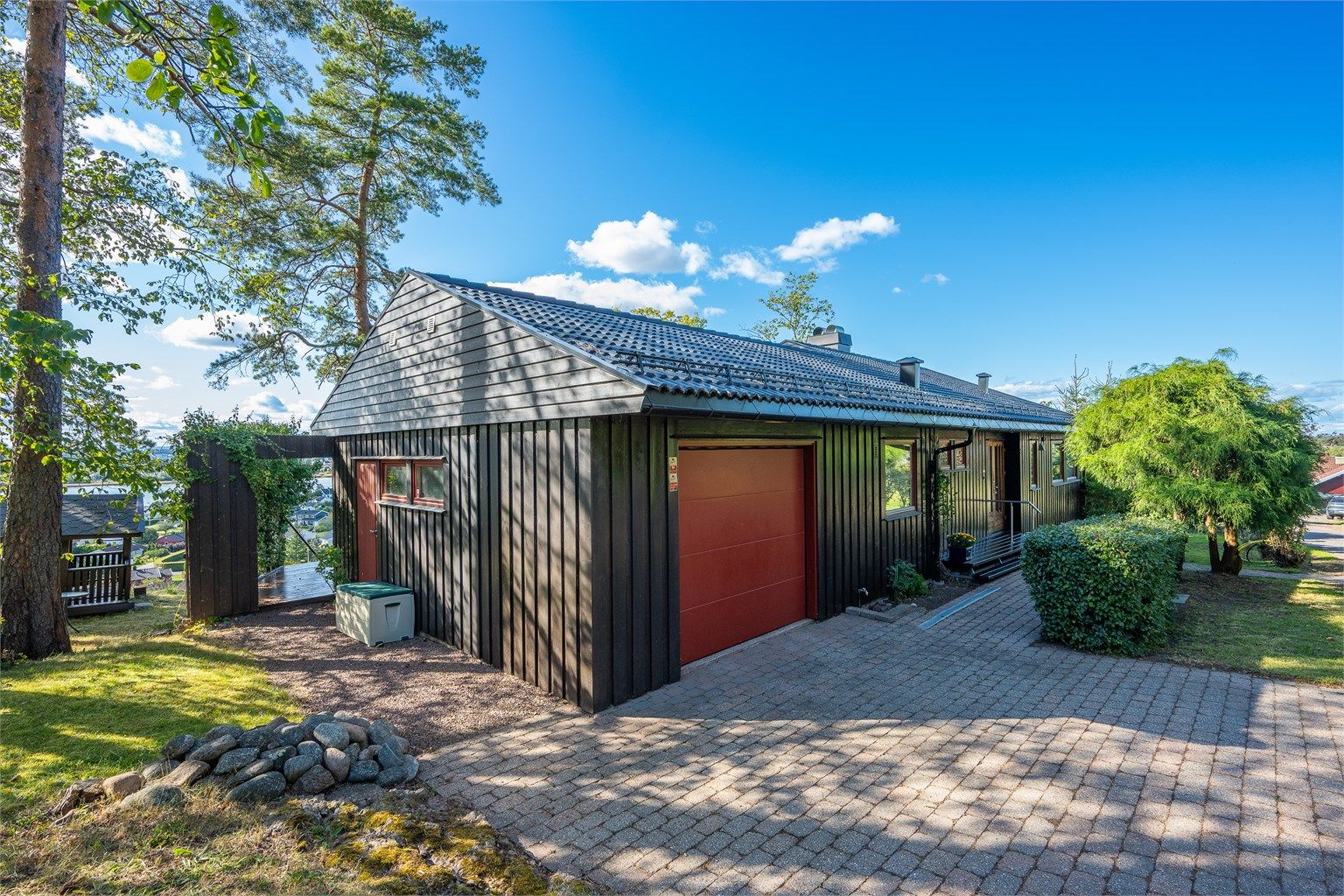 Gårdsplassen er dekket med belegningsstein, som gir et praktisk og pent inngangsparti.