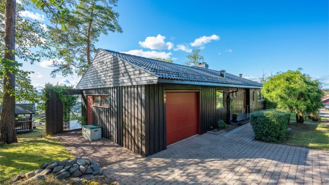 Gårdsplassen er dekket med belegningsstein, som gir et praktisk og pent inngangsparti.