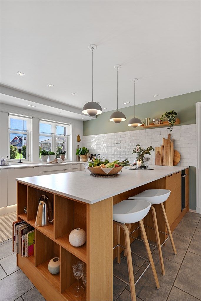 Kjøkkenøya gir en sosial sone med sitteplasser og integrert vinskap.