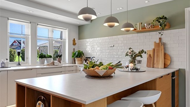 Kjøkkenøya gir en sosial sone med sitteplasser og integrert vinskap.