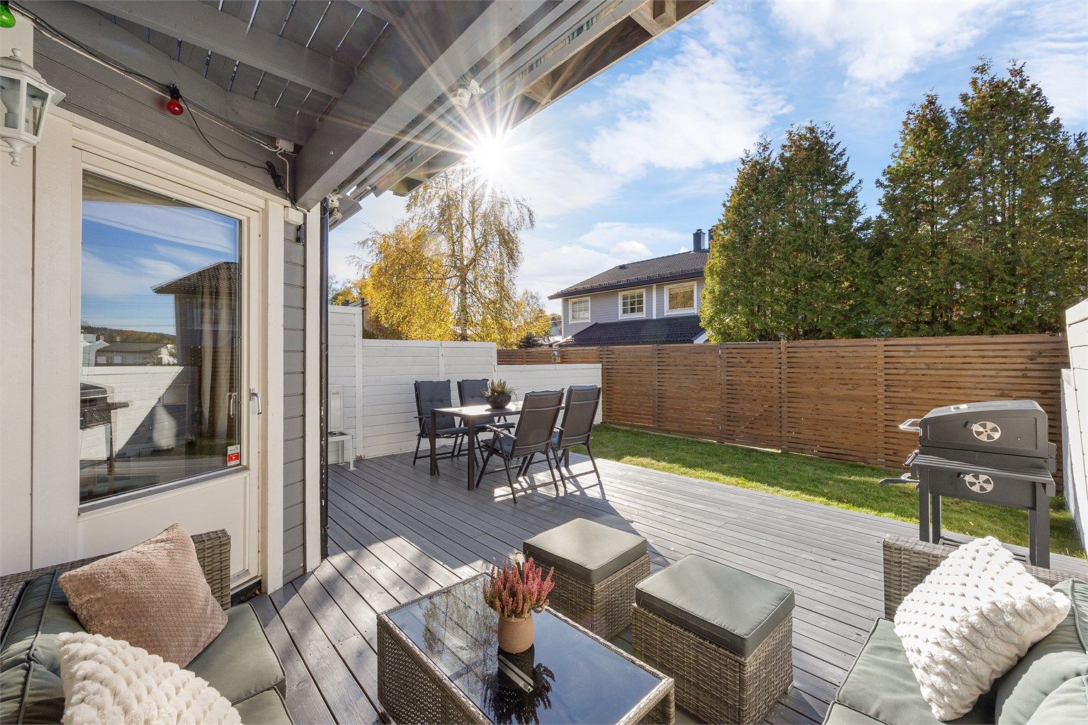Romslig markterrasse i tre med god plass til både spisebord og grill.