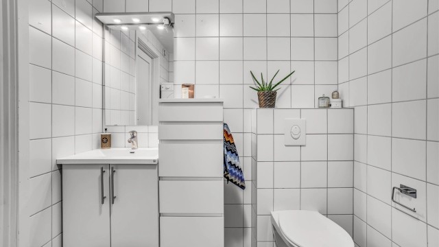 Innbydende bad med flis på både gulv og vegg.