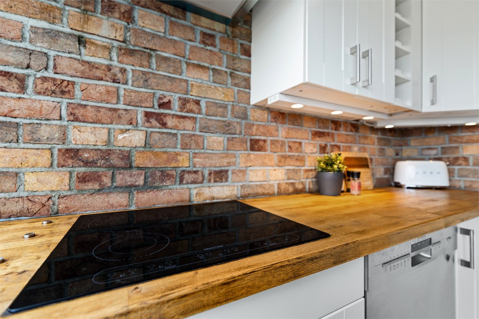 Kjøkkenet har en solid benkeplate i tre og integrert platetopp. For ekstra trygghet er det installert automatisk vannstopper.