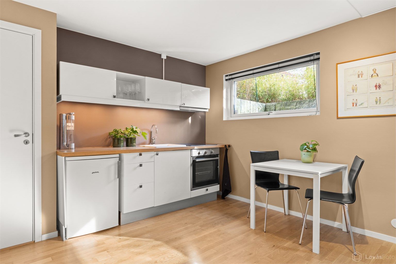 Kjøkkeninnredningen har integrert stekeovn, keramisk platetopp og frittstående kjøleskap.