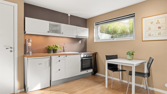 Kjøkkeninnredningen har integrert stekeovn, keramisk platetopp og frittstående kjøleskap.