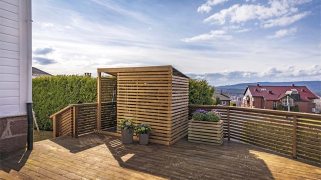 Den store terrassen ved inngangspartiet har en bod/skur med plass til alt fra hageredskaper til lagring av grill