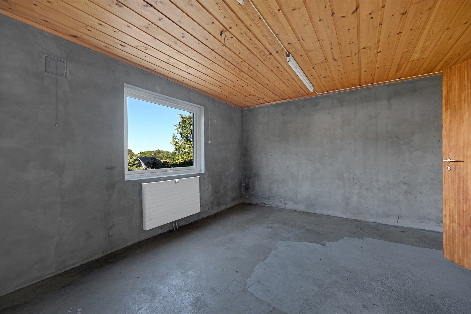 Romslig hobbyrom og lagerrom med radiator på vegg.