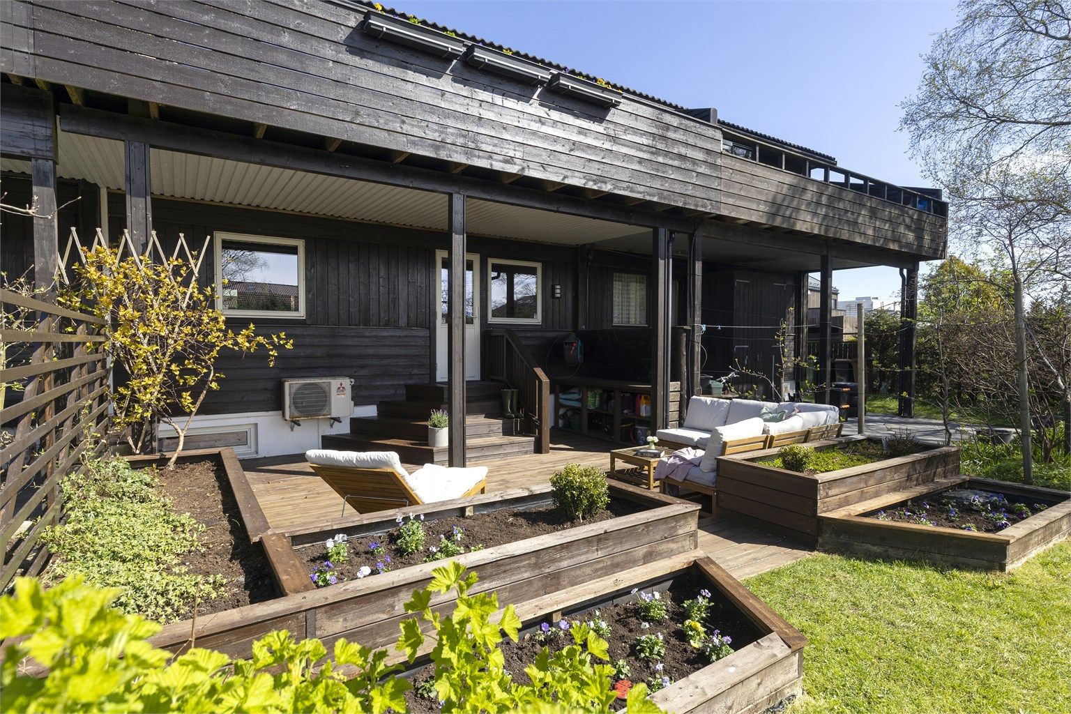 Markterrassen er bygget i flere nivåer med integrerte plantekasser, som skaper en lun og hyggelig sone mot hagen.