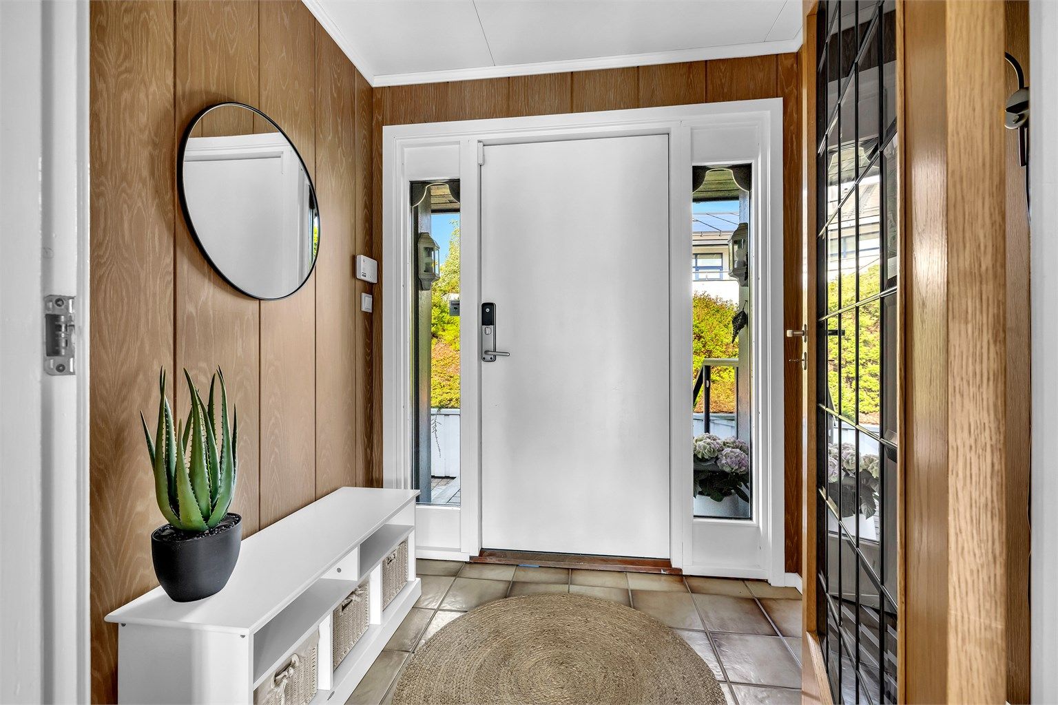 Velkommen inn! Entré med flislagt gulv og praktiske muligheter for å henge fra seg yttertøy og sette fra seg sko. To avlange vinduer gir godt med naturlig lys og skaper en lys og trivelig velkomst.
