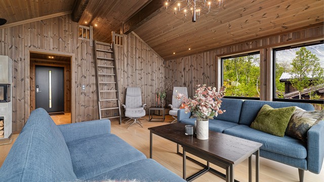 Veggflatene i beiset trepanel skaper en lun og helhetlig hytteatmosfære.