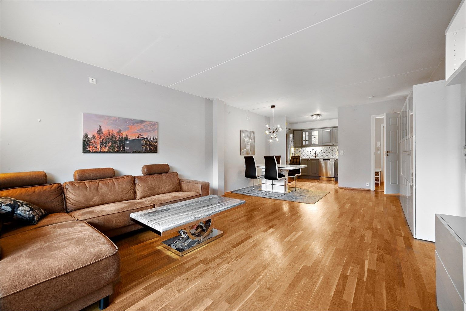 Lys og romslig stue med god plass til sofagruppe, spisestue og tilhørende møblement. 