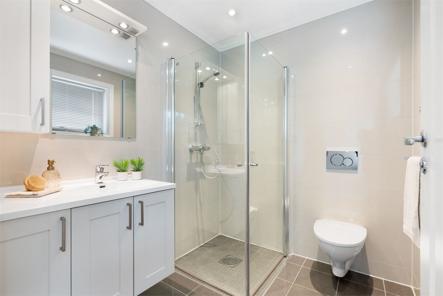 Badet i denne etasjen er helfliset med gulvvarme, og innredet med baderomsmøbler, dusjhjørne og vegghengt wc 