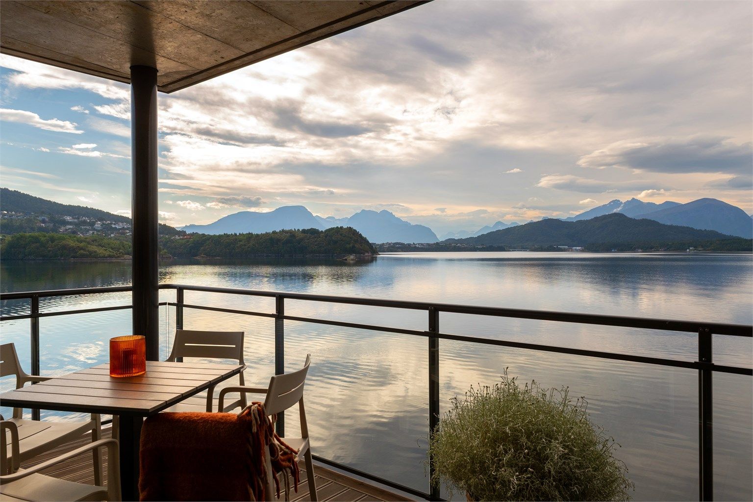 Overbygd terrasse med glassrekkverk med fantastisk utsikt over Borgundfjorden og Sunnmørsalpane - Foto: Stian Wiik