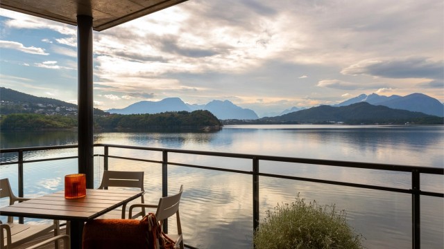 Overbygd terrasse med glassrekkverk med fantastisk utsikt over Borgundfjorden og Sunnmørsalpane - Foto: Stian Wiik