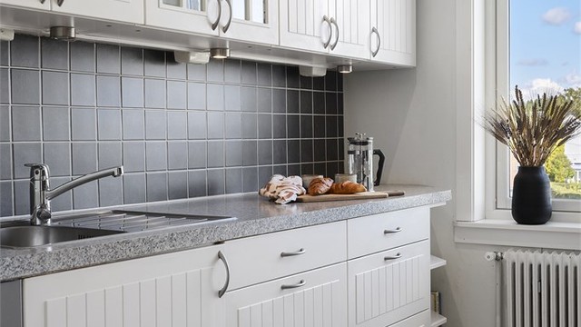 Kjøkkeninnredningen har profilerte fronter og vitrineskap.