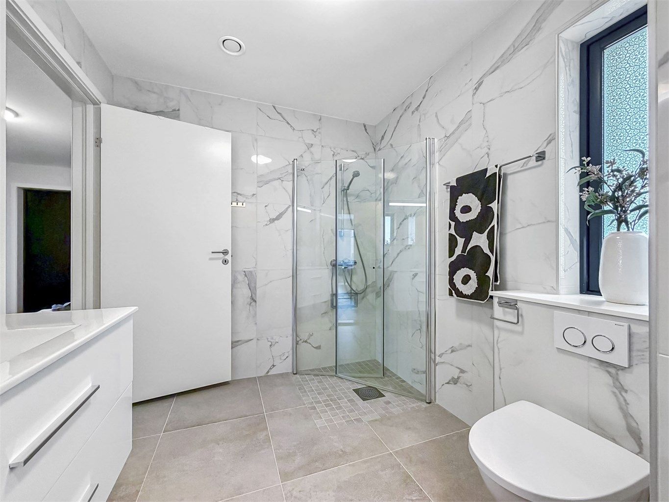 Råflott baderom med marmorimitasjon på vegger. Varmekabler i gulv.