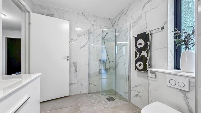 Råflott baderom med marmorimitasjon på vegger. Varmekabler i gulv.