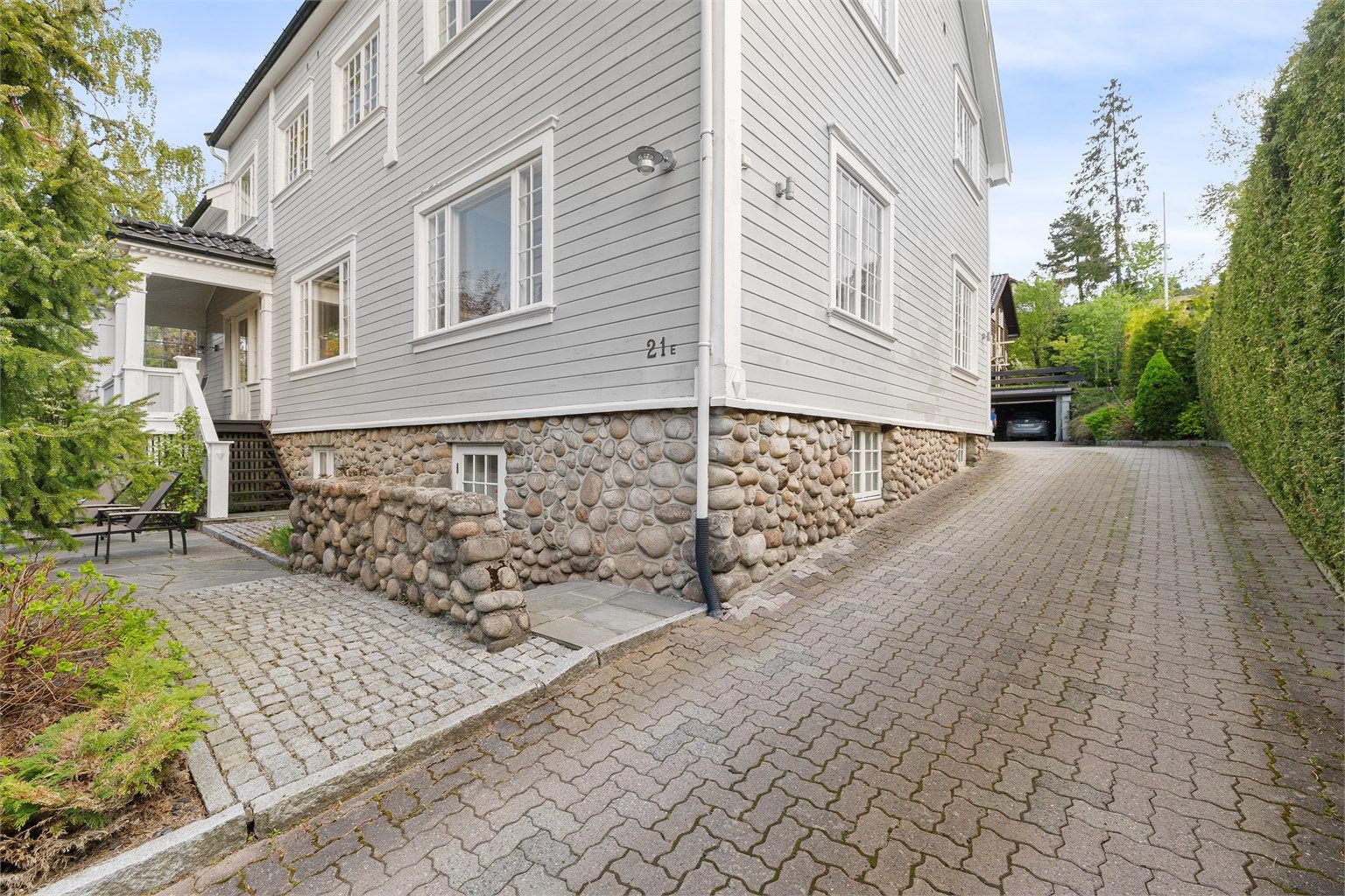 Fasaden er kledd med liggende trekledning, og grunnmuren er i betong med sparestein.