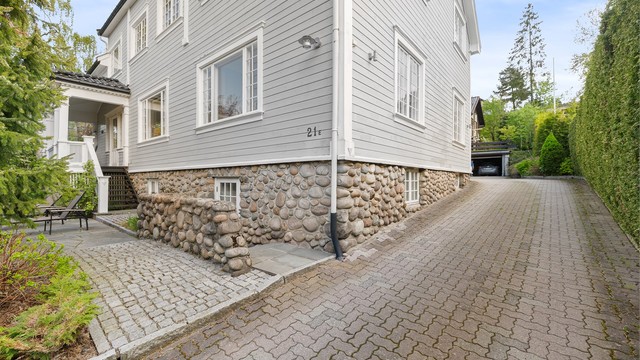 Fasaden er kledd med liggende trekledning, og grunnmuren er i betong med sparestein.
