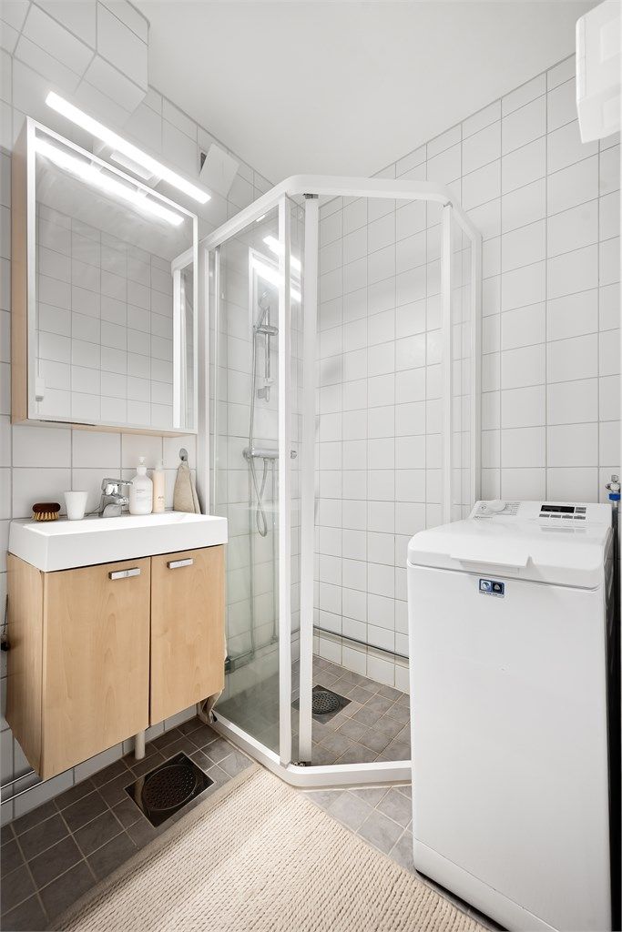 Rommet er innredet med dusjhjørne, servantmøbel og opplegg for vaskemaskin.