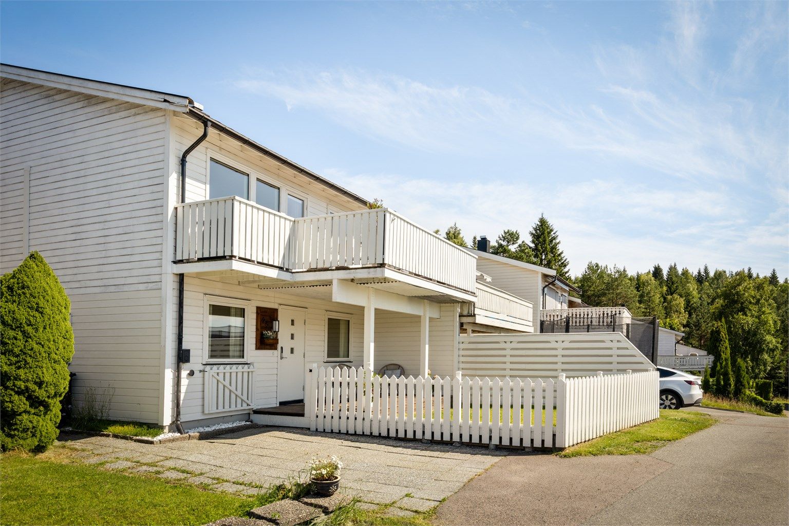 Inngjerdet hage ved inngangspartier og biloppstillingsplass på egen tomt med el-billader montert i 2023. 