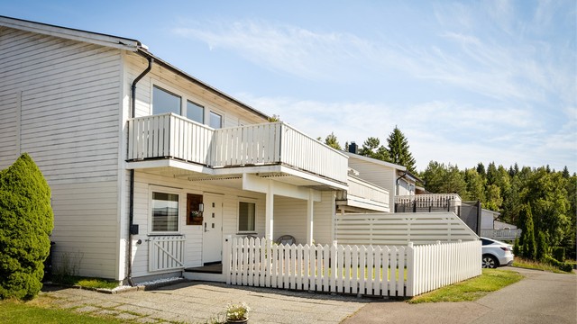 Inngjerdet hage ved inngangspartier og biloppstillingsplass på egen tomt med el-billader montert i 2023.