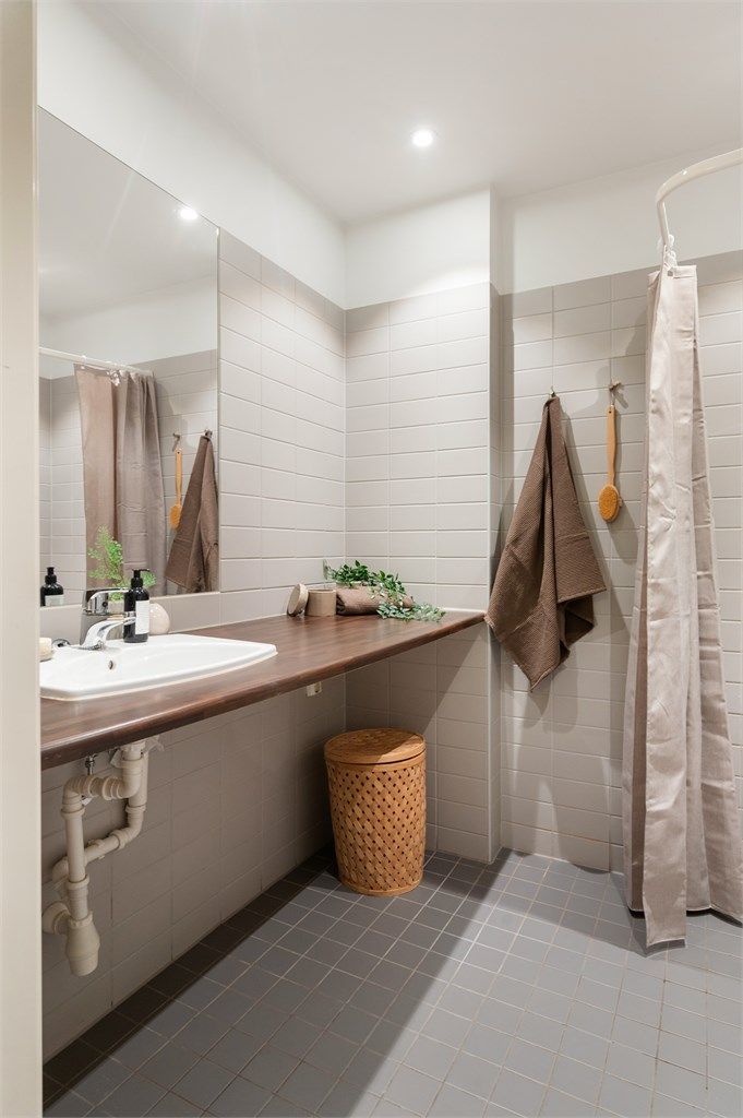 Ellers er det gulvstående toalett og benkeplate i laminat med nedfelt servant. Over servanten er det innfelt speil og belysning med stikkontakt på vegg.