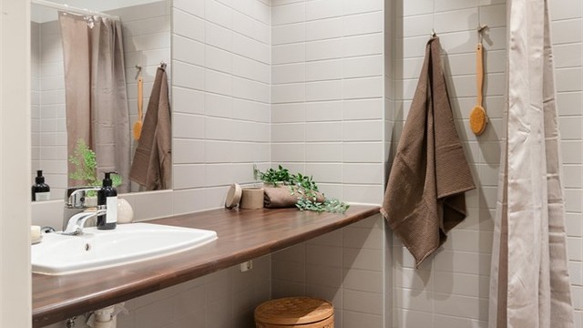 Ellers er det gulvstående toalett og benkeplate i laminat med nedfelt servant. Over servanten er det innfelt speil og belysning med stikkontakt på vegg.