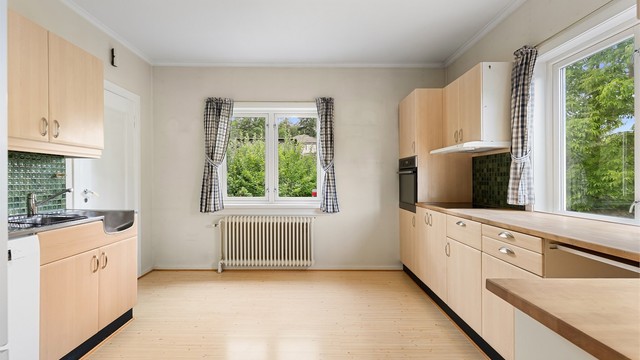 Stort kjøkkenrom som er plasser vegg i vegg med spisestuen