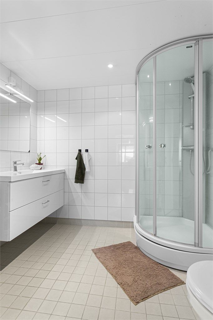  Badet er innredet med vegghengt servantskap med nedfelt servant, speil med overlys, dusjkabinett, vegghengt toalett samt opplegg for vaskemaskin.
