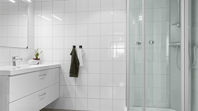 Badet er innredet med vegghengt servantskap med nedfelt servant, speil med overlys, dusjkabinett, vegghengt toalett samt opplegg for vaskemaskin.