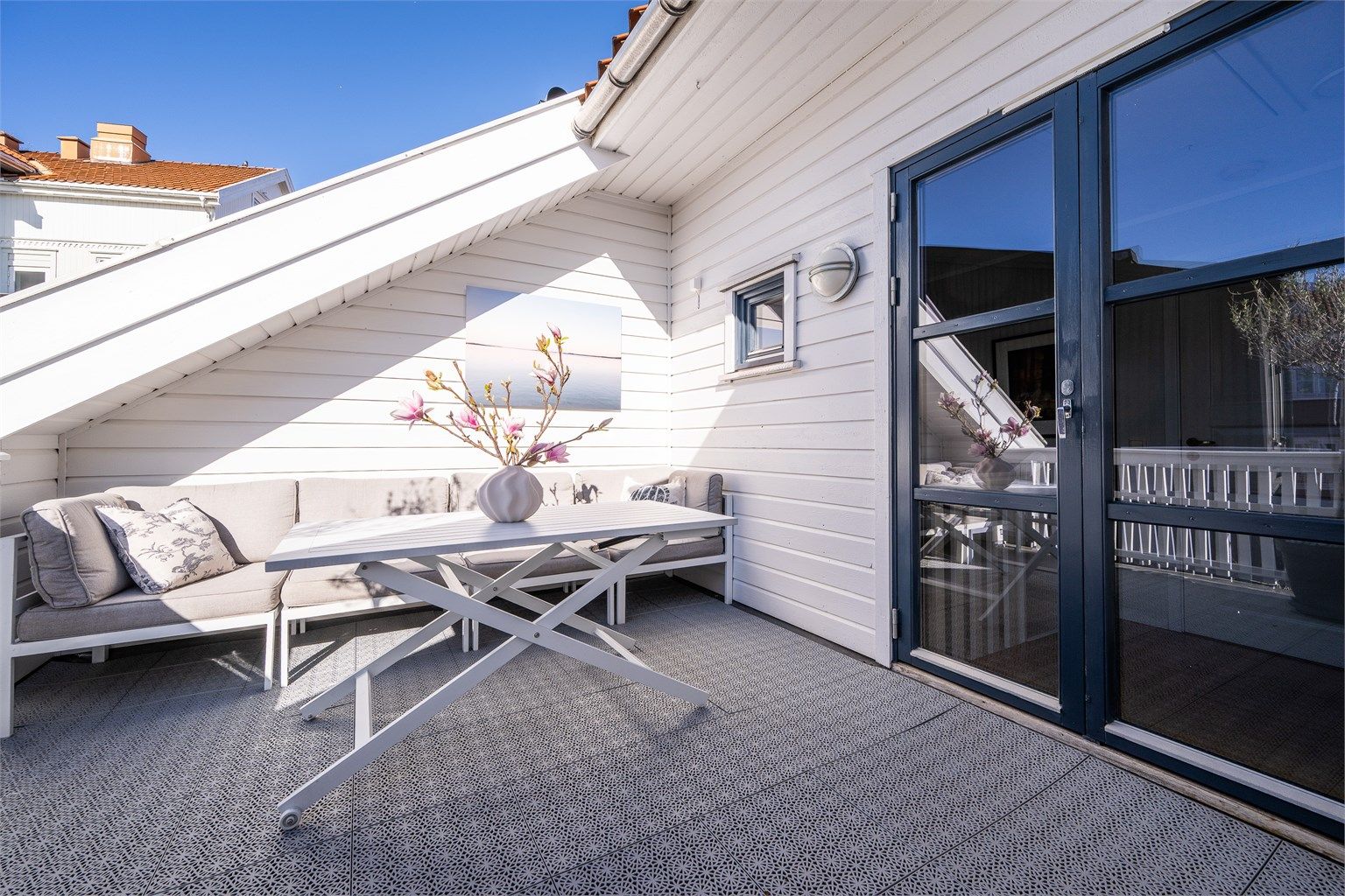 I toppetasjen venter en romslig takterrasse. Herfra har du utsyn over det sjarmerende nabolaget i Tønsberg sentrum.