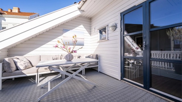 I toppetasjen venter en romslig takterrasse. Herfra har du utsyn over det sjarmerende nabolaget i Tønsberg sentrum.