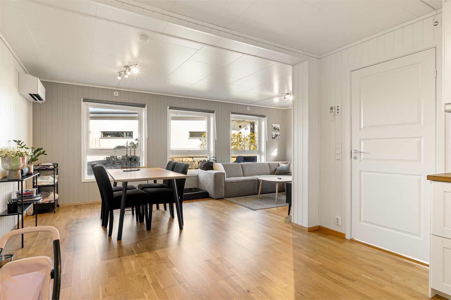 Åpen stue og kjøkken løsning som er formet som en L. Utgang via dør til entré og bod.