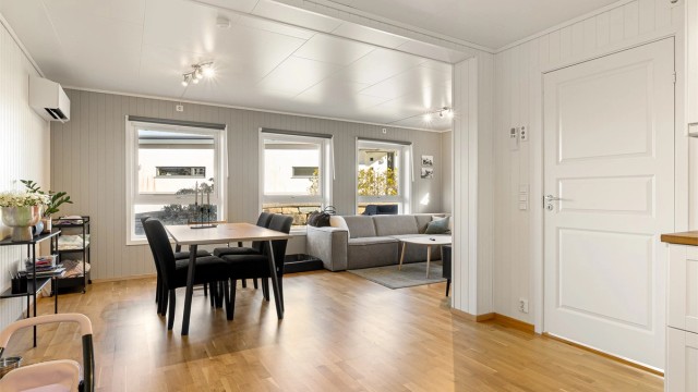 Åpen stue og kjøkken løsning som er formet som en L. Utgang via dør til entré og bod.