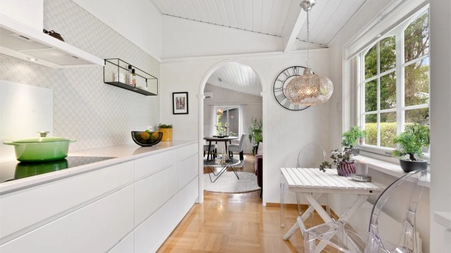 Kjøkkeninnredning fra Kvik (2014) med hvite, glatte fronter og benkeplate i stein