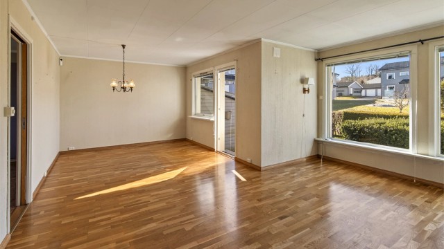Stuen har god plass til både sittegruppe og spisebord, med eikeparkett på gulvet.