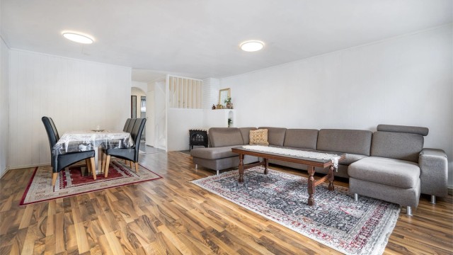 Stuen har god plass til både spisebord og sofagruppe, samt et ildsted for ekstra varme.